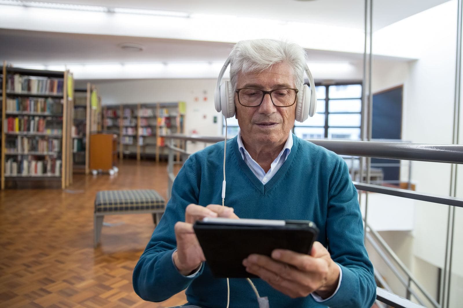 A man wearing headphones and using a tablet